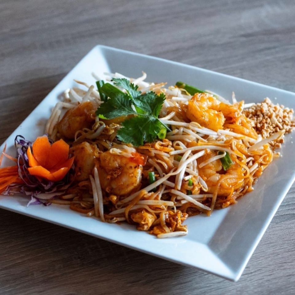 Kanda Thai Cuisine's Pad Thai with shrimp, bean sprouts, cilantro, and crushed peanuts on a white plate.